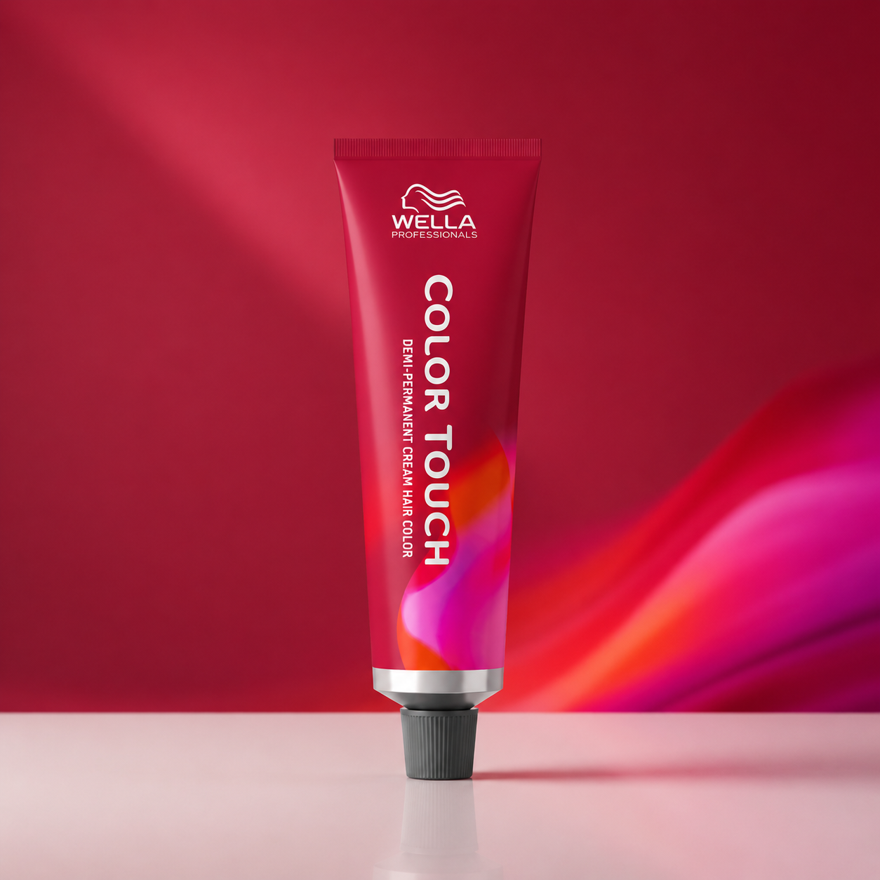 Minimalist premium product image featuring a Wella Color Touch colour tube against a vibrant pink and red gradient background with sleek editorial styling.