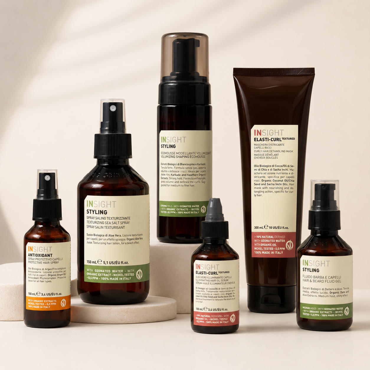 Selection of Insight Styling products including sea salt spray, volumizing mousse, protective spray, curl mask, oil serum and hair & beard fluid displayed on a clean neutral background.