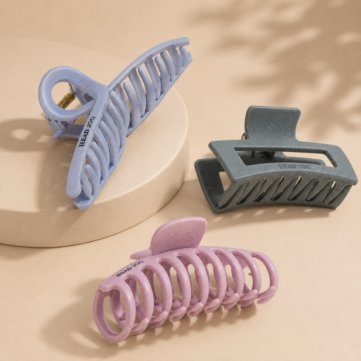 Selection of Head Jog claw clips and hair grips in soft pastel and neutral tones displayed on a clean premium background.
