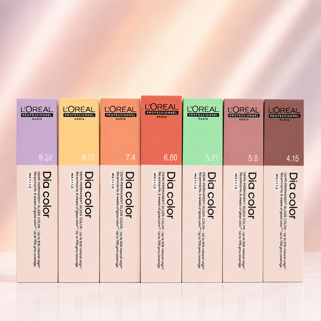 Selection of L'Oréal Professionnel Dia Color demi-permanent hair colour shades in branded packaging with a soft pastel gradient backdrop.